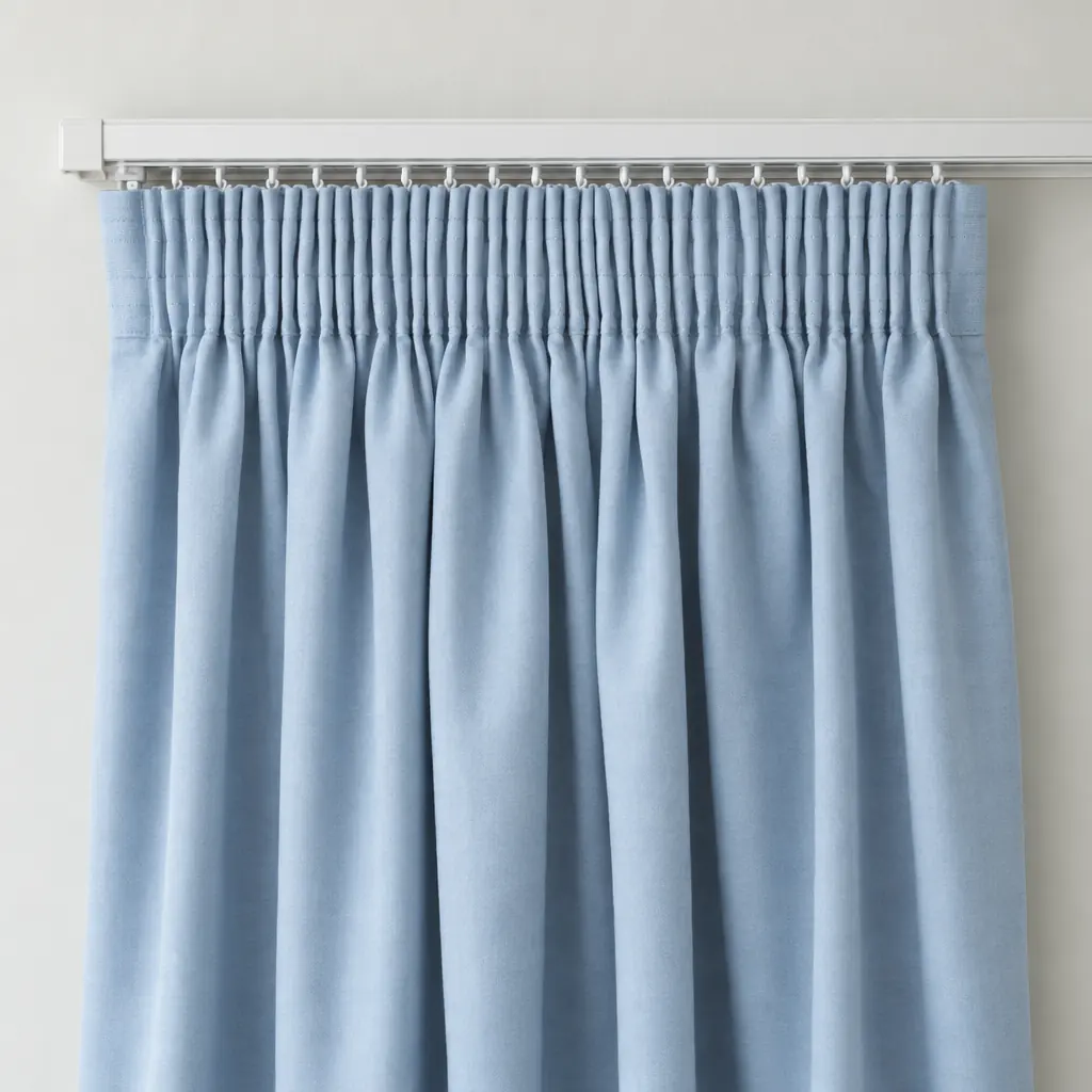Soft blue pencil pleat curtains on a white track, the heading gathered into tight narrow folds